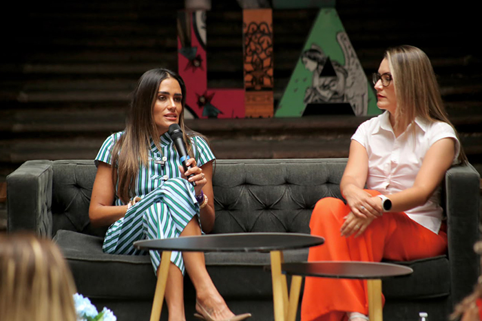 Mujeres reunidas en un evento público escuchando una ponencia sobre liderazgo femenino.
