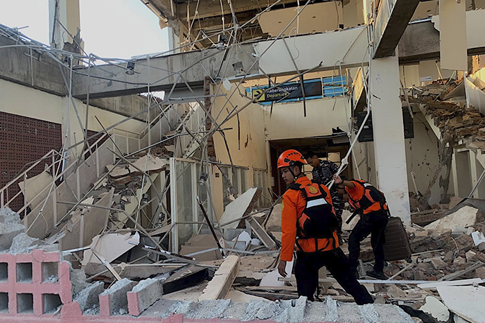 Edificios colapsados y escombros en una calle tras un fuerte movimiento telúrico.