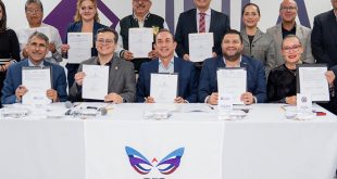 Rectores y autoridades firmando documentos oficiales de colaboración en un presídium.