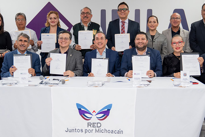 Rectores y autoridades firmando documentos oficiales de colaboración en un presídium.