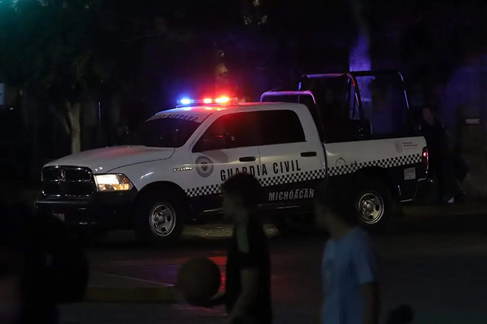 Unidades policiales y de peritaje resguardando una calle residencial tras un reporte de agresión armada.