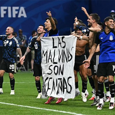 Jugadores de la selección de Argentina sostienen pancarta con la leyenda 'Las Malvinas son argentinas' en el terreno de juego.