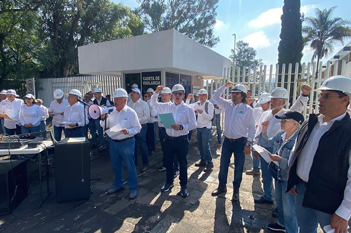Grupo de jubilados manifestándose con pancartas frente a instalaciones de la Comisión Federal de Electricidad.