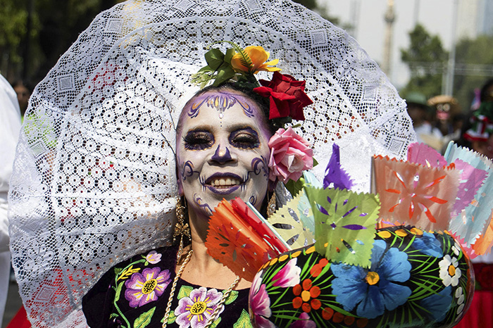 Integrantes de comunidades indígenas portando trajes típicos y máscaras durante una marcha cultural en el Zócalo.