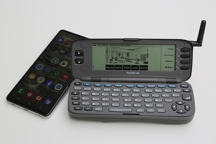 Dispositivo móvil clásico con diseño plegable, teclado físico y pantalla pequeña sobre una superficie oscura.