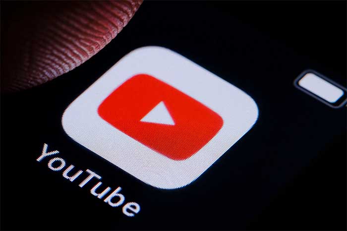 Logotipo de YouTube en una pantalla digital rodeado de iconos de reproducción.