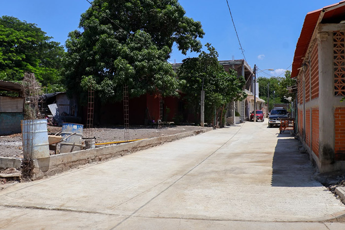 Nueva calle pavimentada con concreto hidráulico y vecinos reunidos durante la inauguración de la obra.