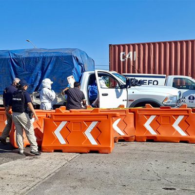 Peritos y elementos de seguridad trabajando junto a una camioneta blanca y contenedores tras el homicidio de un civil en la autopista de Occidente.