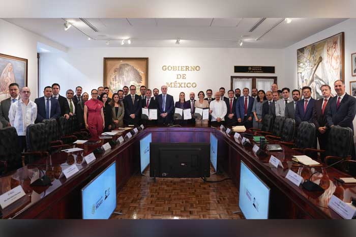 La presidenta Claudia Sheinbaum posa junto a funcionarios y representantes del sector gasolinero en una sala de juntas de Palacio Nacional tras renovar el acuerdo de precios.