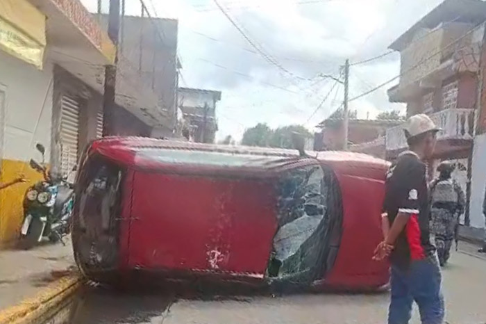 Camión de carga arrastra y vuelca un automóvil estacionado en una calle de Uruapan.
