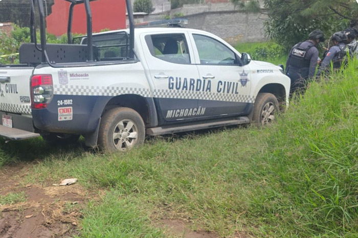 Elementos policiacos resguardan la escena donde un hombre fue asesinado en la colonia Bosques del Oriente, en Uruapan.