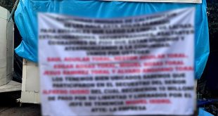 Elementos de seguridad retiran una narcomanta localizada en la comunidad de Caltzontzin, en Uruapan.