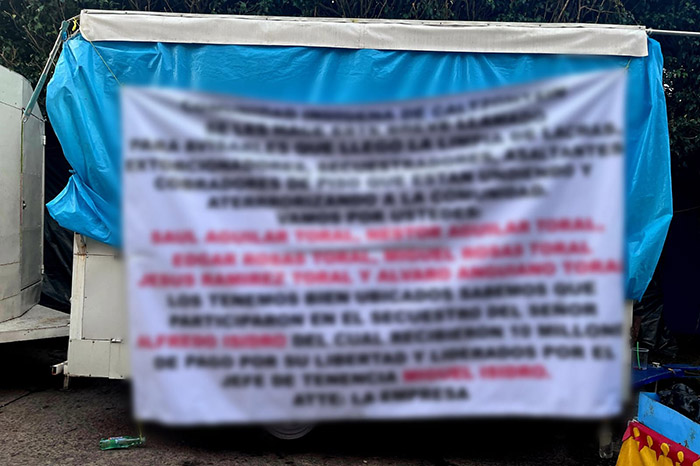 Elementos de seguridad retiran una narcomanta localizada en la comunidad de Caltzontzin, en Uruapan.