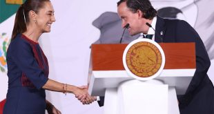 La presidenta Claudia Sheinbaum saluda a Mikel Arriola, directivo de la FMF, frente al atril presidencial.