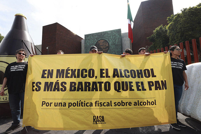 Manifestación de organizaciones civiles frente al Congreso de la Unión con figuras alusivas al costo del alcohol frente a alimentos básicos.