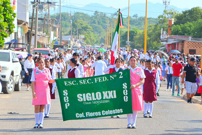 Contingentes escolares y autoridades municipales durante el desfile cívico en Las Guacamayas, Lázaro Cárdenas.