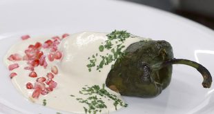 Platillo tradicional de chile en nogada bañado en crema de nuez de Castilla, granada y perejil.