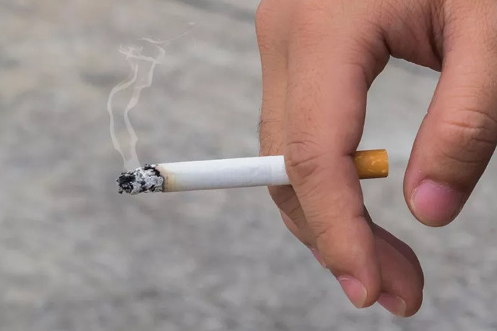 Persona con un cigarro en las manos.