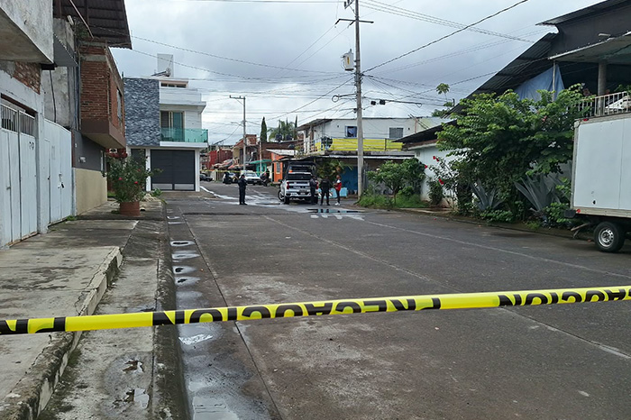Peritos y elementos policiales realizando diligencias en la escena del crimen en la colonia Revolución de Uruapan.