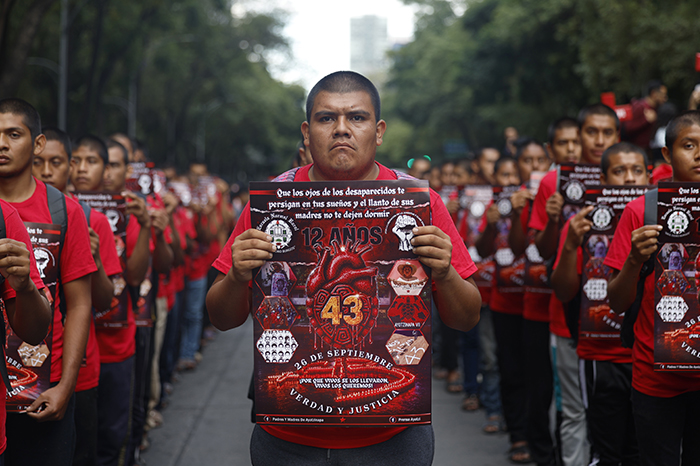 Contingente de familiares y manifestantes avanzando sobre Paseo de la Reforma con mantas y consignas.