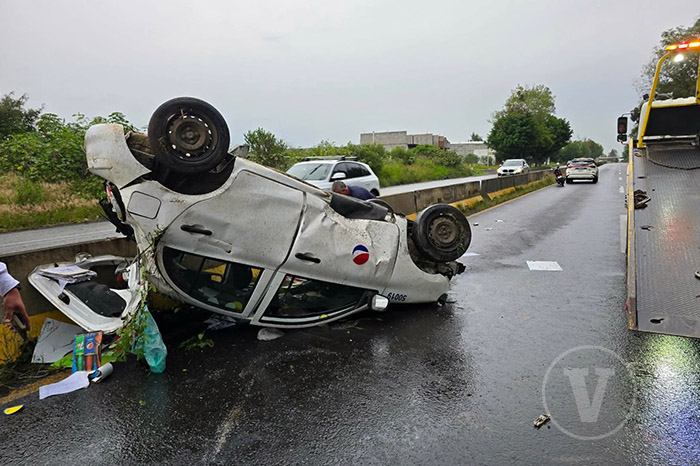 Automóvil rotulado de Pepsi volcado a la orilla de la carretera Morelia-Pátzcuaro tras chocar contra un paredón.