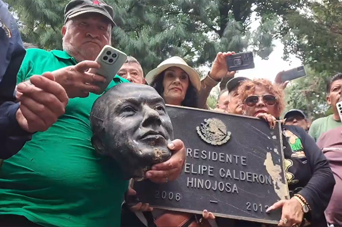Extrabajadores de LyFC golpean estatua de Felipe Calderón en Los Pinos