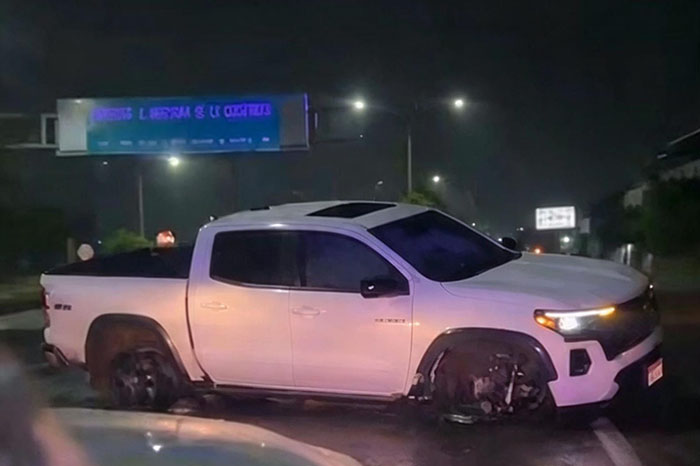Unidades de emergencia y de la Guardia Nacional atendiendo el choque de una camioneta blanca sobre la carretera Apatzingán-Cuatro Caminos.