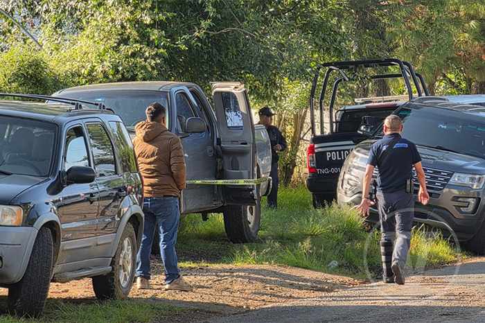 Unidades de la Policía Municipal y ambulancia de Protección Civil en una carretera de Michoacán.