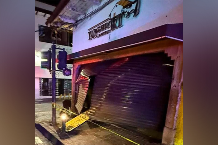 Fachada de un local comercial acordonada por la policía tras un ataque incendiario en Uruapan.