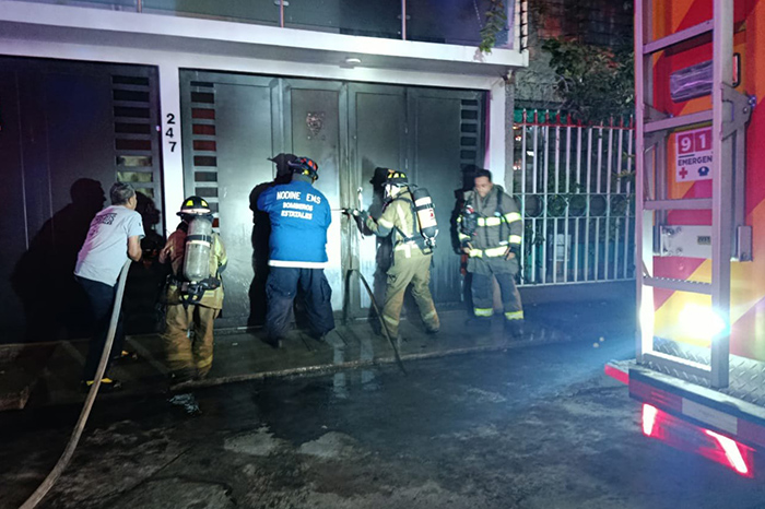 Cuerpos de bomberos y emergencia trabajando frente al inmueble en la calle Pico de Tancítaro tras el incendio.