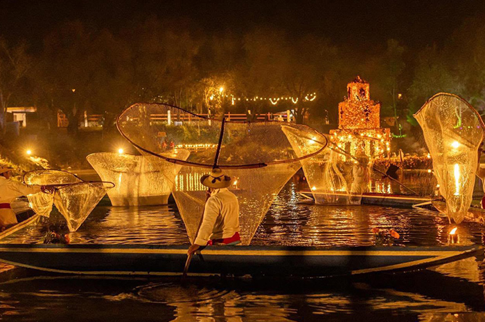 Canoas tradicionales decoradas con cempasúchil y velas recorriendo los canales de Urandén.