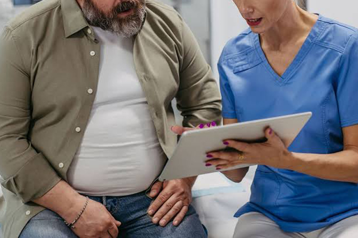 Profesional de la salud ofreciendo asesoría nutricional y médica a un paciente en consultorio.