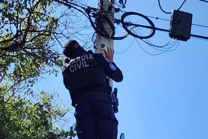 Agentes de la Fiscalía General del Estado de Michoacán retirando un dispositivo de videovigilancia de un poste en Apatzingán.