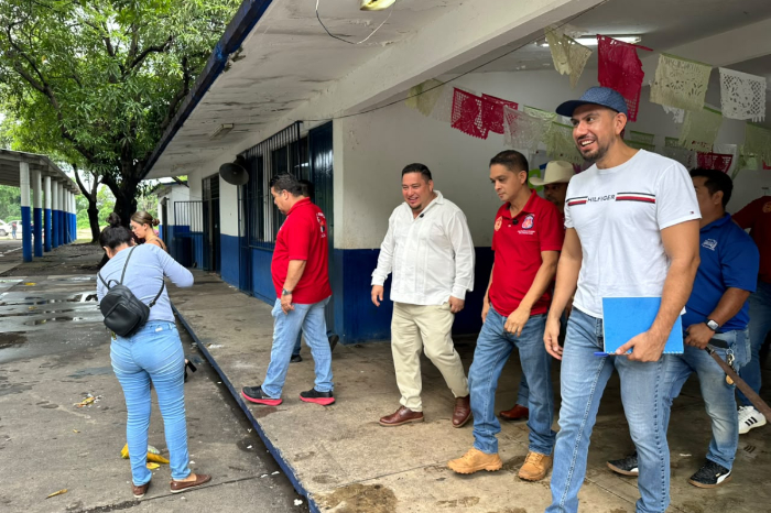 Autoridades municipales, padres de familia y mineros realizando labores de mantenimiento en la Escuela Primaria 1.º de Mayo.