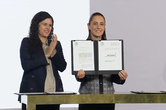 Presidenta de México firmando decreto oficial en conferencia matutina.