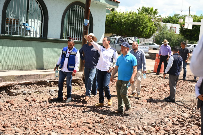 El presidente municipal Carlos Soto supervisando los trabajos de pavimentación junto a vecinos y funcionarios.