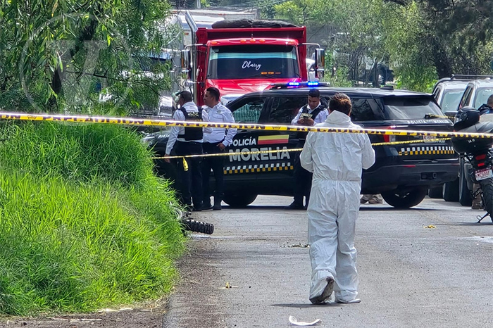 Perito de la Fiscalía General del Estado fijando evidencias e indicios en la escena de un crimen vial.