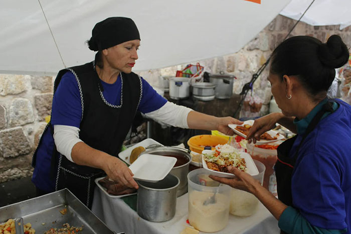 Comerciantes preparando enchiladas y corundas en la explanada de San Agustín en Morelia.