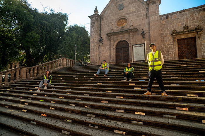 Estudiantes de la UNLA e integrantes del público instalando espejos en las escalinatas del Teatro José Rubén Romero en el Centro Histórico de Morelia.
