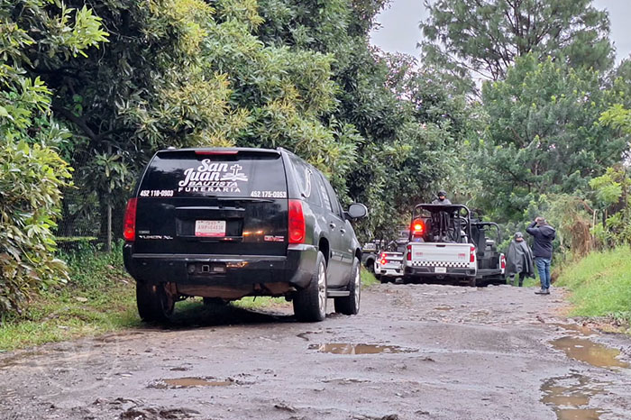 Unidades de la Guardia Nacional y la Policía Acordonando una brecha de terracería en Uruapan.
