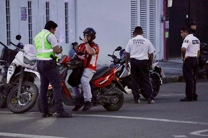 Elementos de la Guardia Civil inspeccionando documentos a un conductor de motocicleta en un punto de revisión en Morelia.