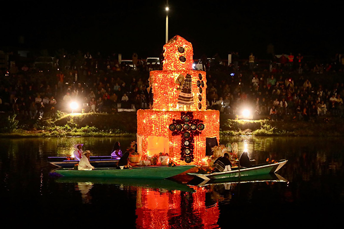 Canoa tradicional adornada con flor de cempasúchil sobre los canales iluminados de Urandén.
