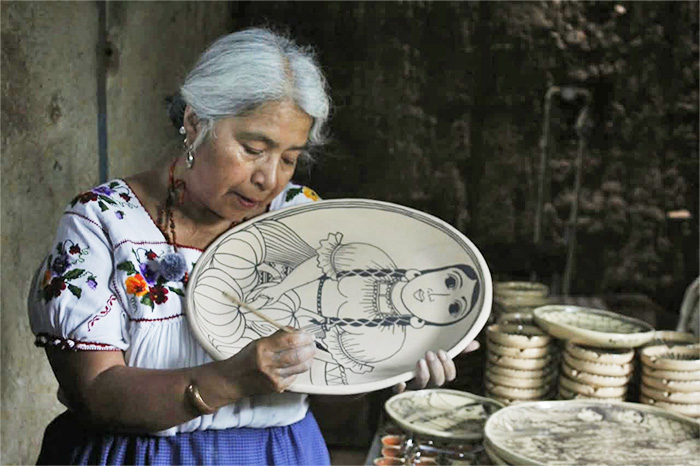 Manos artesanas modelando y decorando piezas de barro con técnicas tradicionales en Tzintzuntzan.