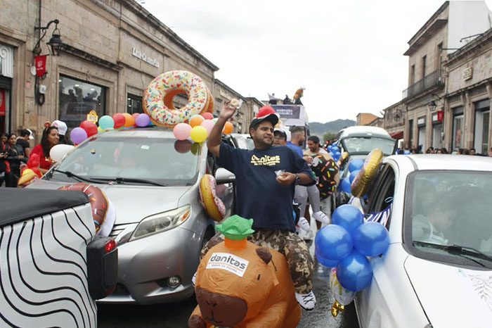 Panaderos locales repartiendo piezas de pan a familias sobre la avenida Madero en el Centro Histórico de Morelia.
