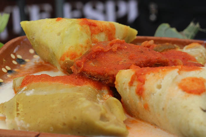 Platillos tradicionales de la gastronomía michoacana, como enchiladas placeras y corundas, preparados en el Mercado San Agustín de Morelia.